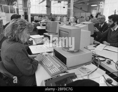 1987, giornalisti che utilizzano personal computer (PC) in un ufficio di giornali affollato. Gli editori di giornali sono stati uno dei primi a vedere l'enorme potenziale dei PC per rendere i loro metodi di lavoro più efficienti e convenienti, rispetto al vecchio metodo di composizione dei metalli ad alta intensità di lavoro. Foto Stock