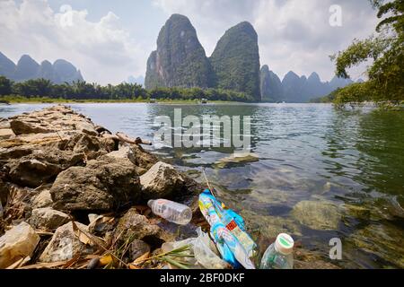 Xingping, Cina - 18 settembre 2017: Spazzatura di plastica sulla riva del fiume li, una delle principali attrazioni turistiche della Cina. Foto Stock