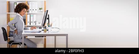 Lesioni da mal di schiena dovute a postura errata seduta in ufficio Foto Stock