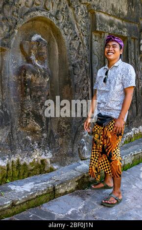 Ritratto verticale di una guida turistica locale a Yeh Pulu Relief a Bali, Indonesia. Foto Stock