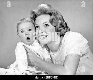 1960 DONNA SORRIDENTE MADRE TENENDO ABBRACCIARE BAMBINA FIGLIA CON SORPRESA ALLARMATA VISO ESPRESSIONE - B21042 HAR001 HARS VECCHIO MODO 1 GIOVANE VISO PAURA COMUNICAZIONE BIONDA BAMBINO FELICE FAMIGLIE GIOIA STILE DI VITA FEMMINE STUDIO SHOT HOME VITA COPIA SPAZIO METÀ LUNGHEZZA SIGNORE ESPRESSIONI B&W CONTATTO OCCHIO FELICITÀ ALLEGRO SORRISI SPAVENTOSO GIOVINEZZA MID-ADULT MOMS DONNA MOMS WOW BABY GIRL NERO E BIANCO ETNIA CAUCASICA HAR001 VECCHIO STILE Foto Stock