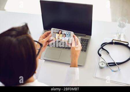 Video chiamata medico online di consulenza medica. Il pediatra terapista femminile ascolta la paziente di una donna e di sua figlia con i sintomi di influenza del virus della febbre Foto Stock