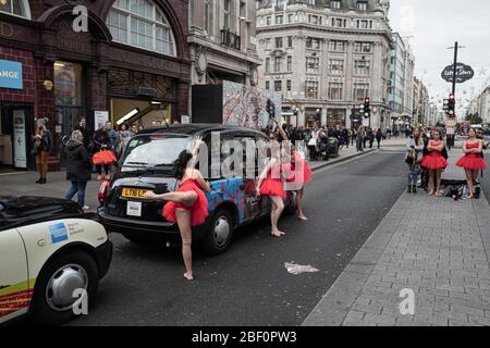 Ballerini classici vestiti in rosso che si esibiscono per strada a Londra, Regno Unito Foto Stock