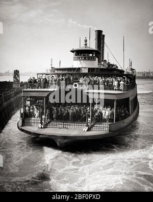 I PASSEGGERI DEGLI ANNI '30 SI SONO SCHIERATI PRONTI A USCIRE DAL TRAGHETTO STATEN ISLAND MENTRE SI TIRA VERSO IL TERMINAL SOUTH FERRY SU LOWER MANHATTAN NYC USA - Q38274 CPC001 HARS PERSONE UNITED STATES OF AMERICA MUSCES TRANSPORTATION B&W NORTH AMERICA COMMUTA NORTH AMERICAN HIGH ANGLE AVVENTURA PENDOLARI SERVIZIO CLIENTI ECCITAMENTO ESTERNO SU NYC CITTÀ DI NEW YORK TRAGHETTO ELEGANTE CITTÀ DI NEW YORK STATEN ISLAND TRAGHETTO COOPERAZIONE SOUTH TERMINAL TRAGHETTI INSIEME NERO E BIANCO USCITA VECCHIO STILE TIRA STATEN Foto Stock