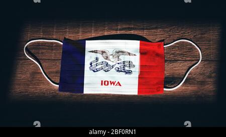 Bandiera Iowa. Coronavirus Covid 19 nello Stato degli Stati Uniti. Maschera medica isolato su sfondo nero. Maschere facciali e per la bocca per la protezione contro l'infezione aerea Foto Stock