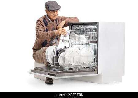 Uomo anziano che carica una lavastoviglie e sorridente isolato su sfondo bianco Foto Stock