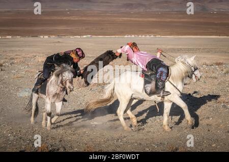 Due kazaki a cavallo al tradizionale gioco Kokbar, provincia di Bajan-Oelgii, Mongolia Foto Stock