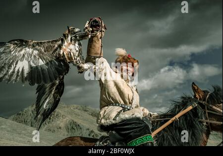 Cacciatore di aquile mongolo, Kazakhs a cavallo con aquila addestrata, provincia di Bajan-Oelgii, Mongolia Foto Stock