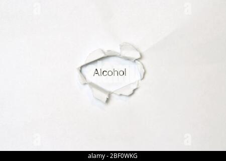 Parola alcol su sfondo bianco isolato, l'iscrizione attraverso il foro avvolto nella carta. Foto di scorta per il Web e stampa con spazio vuoto per testo e design. Foto Stock