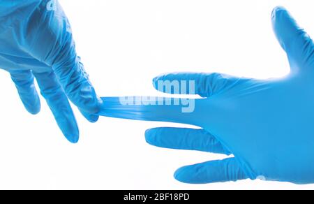 Mani che indossano guanti in lattice blu per uso medico protezione contro influenza, virus e coronavirus. Assistenza sanitaria e concetto chirurgico. Modo corretto di rimuovere il prote Foto Stock