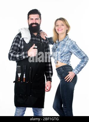Cucina con passione. Weekend per famiglie. Uomo barbuto ippico e ragazza. Preparazione e culinario. Attrezzi per arrostire carne. Coppia in amore tenere utensili da cucina. Barbecue a picnic. Ricetta per cucinare cibo. Foto Stock