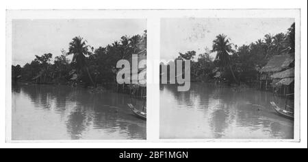 Tipica vista di un Klong tailandese (Khlong) con cottage coperti di canna lungo il corso d'acqua. Fotografia di circa 1910. Foto su lastra di vetro asciutta della collezione Herry W. Schaefer. Foto Stock