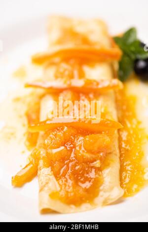 Primo piano di crepes con zucchero in polvere e marmellata su un piatto Foto Stock