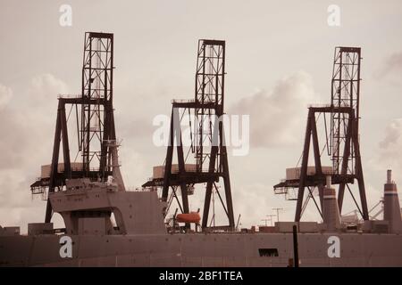 SS Cape Mohican SEABEE portaerei e nave da guerra al terminal internazionale container con gru di spedizione. Porto esterno, porto di Oakland. Foto Stock