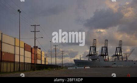 Nave da guerra portavalori SS Cape Mohican SEABEE presso terminal container per spedizioni internazionali con gru di spedizione. Outer Harbour, Porto di Oakland, Stati Uniti. Foto Stock