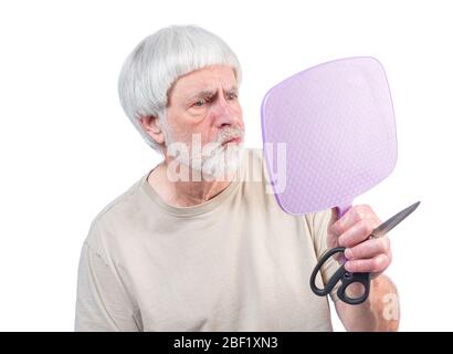 Colpo orizzontale di un uomo grigio a capelli che è stato in quarantena troppo a lungo guardando il taglio di capelli che ha appena dato e non è sicuro circa i risultati. Foto Stock