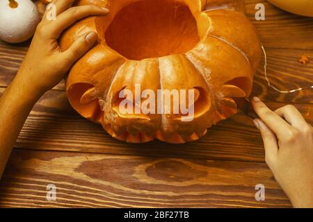 Vacanze, Halloween, decorazione e concetto di gente - primo piano di donna con zucche a casa Foto Stock