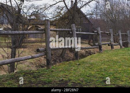 Recinto di legno vecchio con casa rurale dietro. Vista sulla campagna Foto Stock