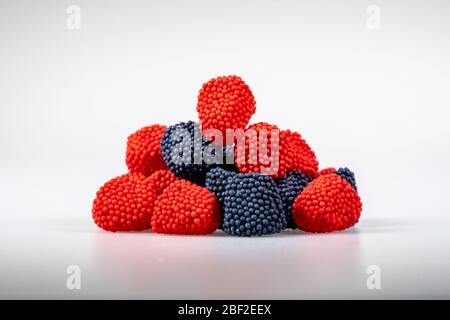 Mucchio di caramelle gommose aromatizzate alla frutta su bianco Foto Stock