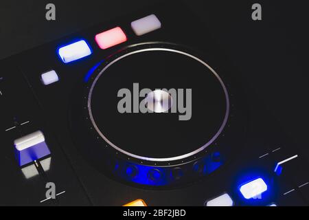 DJ Sound mixer controller con manopole e cursori primo piano. Mixer audio con giradischi al buio con comandi illuminati Foto Stock