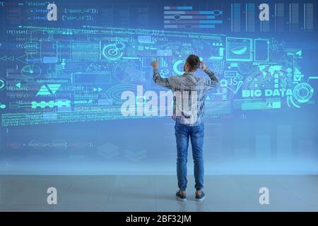 Programmatore maschio che utilizza schermo virtuale, vista posteriore Foto Stock