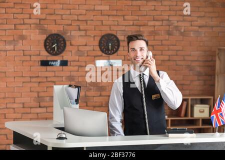 Receptionist maschio parlando al telefono in hotel Foto Stock