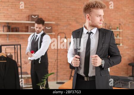 Seamster abito di sartoria per client maschio in atelier Foto Stock