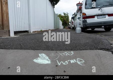 Covid-19, Coronavirus, crisi pandemica a Melbourne Australia 2020. Messaggio di gesso di soggiorno a casa scritto su un sentiero in una via Melbourne. Foto Stock