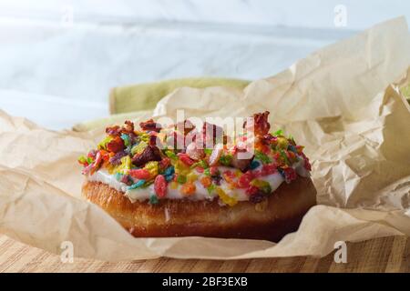 Trendy pancetta fruttato arcobaleno ciambella di cereali in carta pergamena Foto Stock