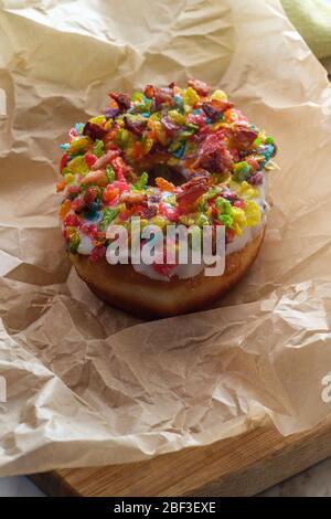 Trendy pancetta fruttato arcobaleno ciambella di cereali in carta pergamena Foto Stock