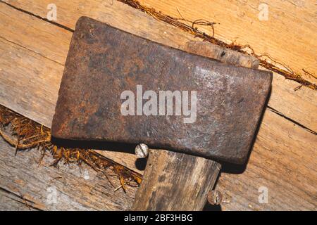 L'ascia vecchia è appesa a muro di legno. Strumento manuale. Utensile di lavoro Foto Stock