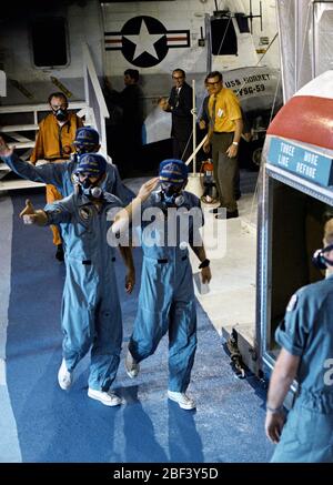 (24 nov. 1969) --- USS Hornet marinai sono accolti dal personale dell'equipaggio dell'Apollo 12 atterraggio lunare missione come i tre astronauti sono trasferiti da un U.S. Navy in elicottero in un Mobile impianto di quarantena (MQF) a bordo del primo recipiente di recupero. Charles Conrad Jr., diritto, comandante; Richard F. Gordon Jr., il pilota del modulo di comando anteriore sinistra; e Alan L. Fagiolo, modulo lunare pilota, spruzzato verso il basso in modo sicuro al 2:58 p.m., nov. 24, 1969. Foto Stock