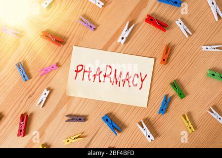 Scrittura a mano testo farmacia. Negozio di fotografia concettuale o dispensario ospedaliero dove le droghe medicinali sono vendute le carte colorate clothespin legno di promemoria vuoto Foto Stock
