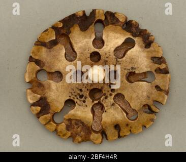 Pulsante. Bottone realizzato con una sezione di corno di renna; fori rotondi e a forma di toppa e tacche sul bordo.sulla scheda 2 Foto Stock