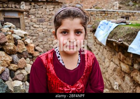 Palangan, Kurdistan iraniano - 15 novembre 2013: Ritratto di ragazza curda carina con vestito rosso in posa nella città vecchia di Palangan Foto Stock