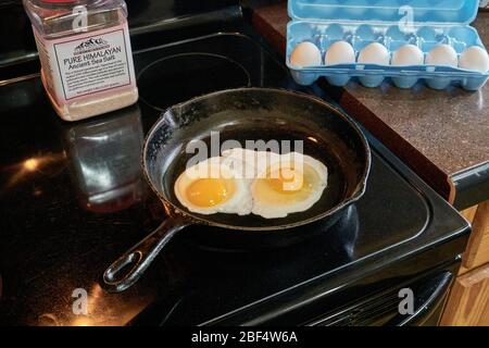 Colazione due sole con uova sfrittate in ghisa Skillet Foto Stock