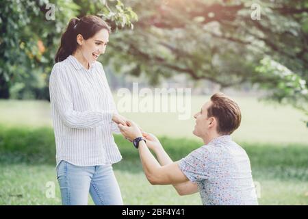 Foto di impegni, proposte di matrimonio, e coppie di recente fidanzato amante giovane uomo e donna parco verde all'aperto. Foto Stock