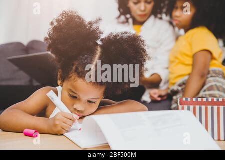 American Black preschool figlia bambini fare istruzione di apprendimento a casa con la sorella che vivono insieme a casa. Foto Stock