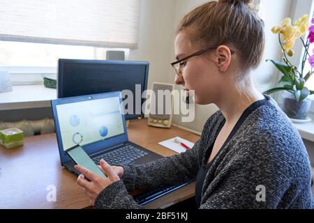 Donna d'affari che lavora da casa, che controlla lo smartphone Foto Stock