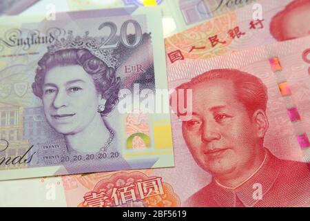 Le banconote in sterlina britannica e yuan cinese in renminbi sono state collocate l'una all'altra. Messa a fuoco selettiva. Concetto per denaro, economia, finanza, valuta Foto Stock