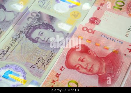 Le banconote in sterlina britannica e yuan cinese in renminbi sono state collocate l'una all'altra. Messa a fuoco selettiva. Concetto per denaro, economia, finanza, valuta Foto Stock
