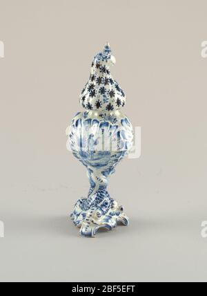 ruota. base a spirale di 6 piedi, gambo formato da 3 delfini ritorti; corpo a conchiglia a 3 lati; parte superiore ritorta a forma di cappuccio con fori forati, sormontata da piccolo finale a spirale; dipinta in blu sottoscallo su bianco con delfini su gambo, uomo con violino su un pannello laterale, fl Foto Stock