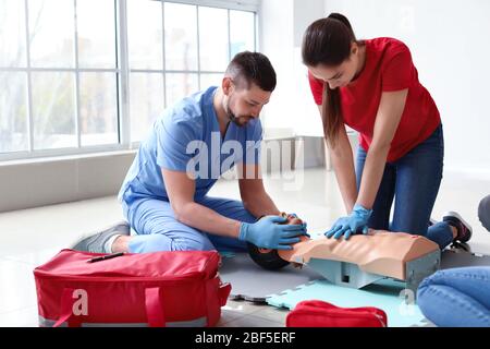 Istruttori che dimostrano la RCP su manichino durante il corso di formazione di primo soccorso Foto Stock