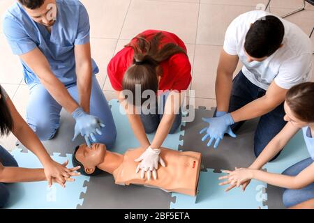 Istruttori che dimostrano la RCP su manichino durante il corso di formazione di primo soccorso Foto Stock