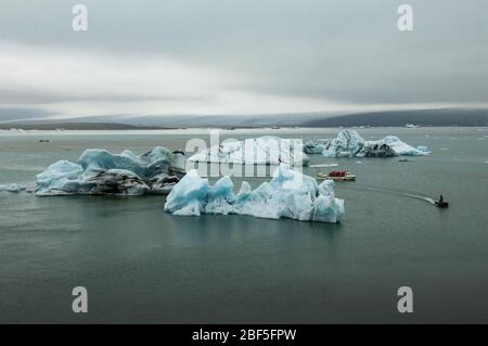 Ghiacciai e barca per escursioni nella laguna del ghiacciaio di Jokulsarlon, sulla costa meridionale dell'Islanda, in Europa Foto Stock