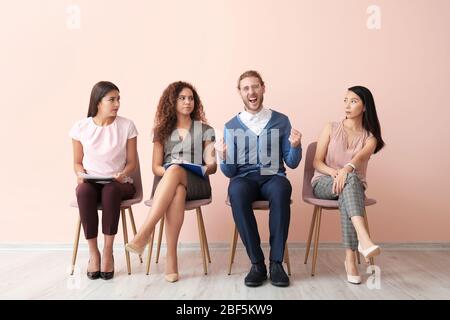 Persone che guardano l'uomo felice che ha superato con successo colloquio di lavoro Foto Stock