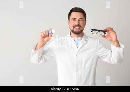 Oftalmologo con lenti a contatto e occhiali su sfondo chiaro Foto Stock