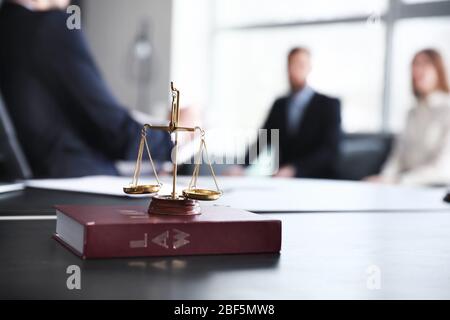 Scale di giustizia con libro di legge sulla tavola del notaio in carica Foto Stock