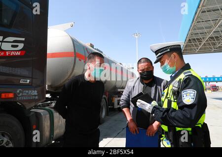 Jiuquan, provincia cinese di Gansu. 16 Apr 2020. L'ufficiale di polizia stradale Wang Yongbin controlla il transito presso un checkpoint nella città di Mazongshan di Jiuquan, nella provincia di Gansu della Cina del nord-ovest, 16 aprile 2020. La polizia stradale tiene veloce alle loro posizioni per garantire la sicurezza dei trasporti nella città di Mazongshan, una città di confine con l'ambiente naturale duro situato nella provincia di Gansu della Cina del nord-ovest. Credit: Du Zheyu/Xinhua/Alamy Live News Foto Stock