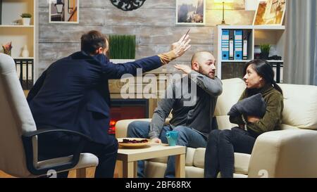 L'uomo arrabbiato così pazzo alla terapia di coppia che prova a colpire la sua moglie. Cattivo matrimonio. Foto Stock